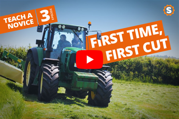 Nybegynder lærer at slå græs med en John Deere 6155 M